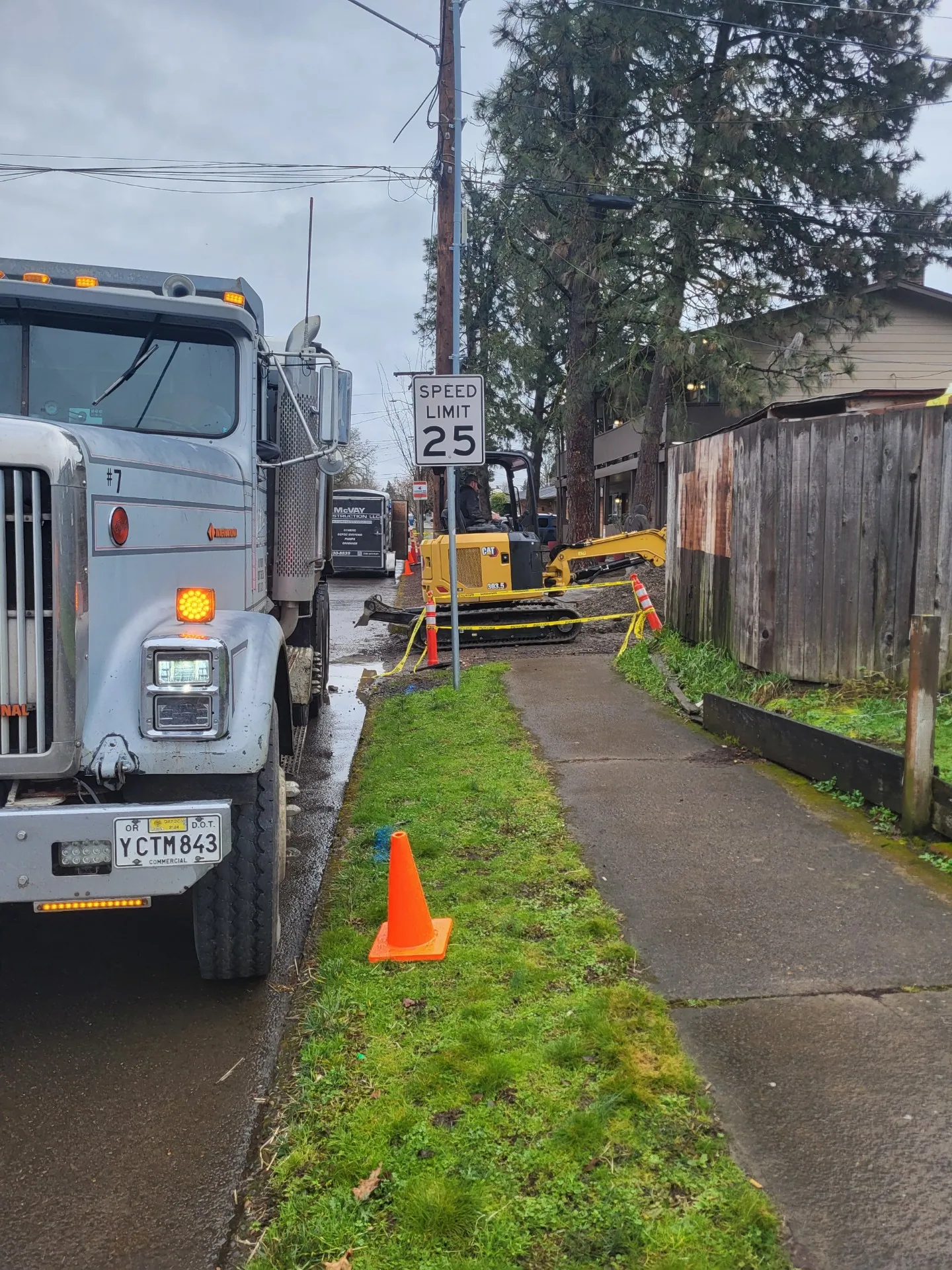 Dump truck and mini excavator on a street-side trench job